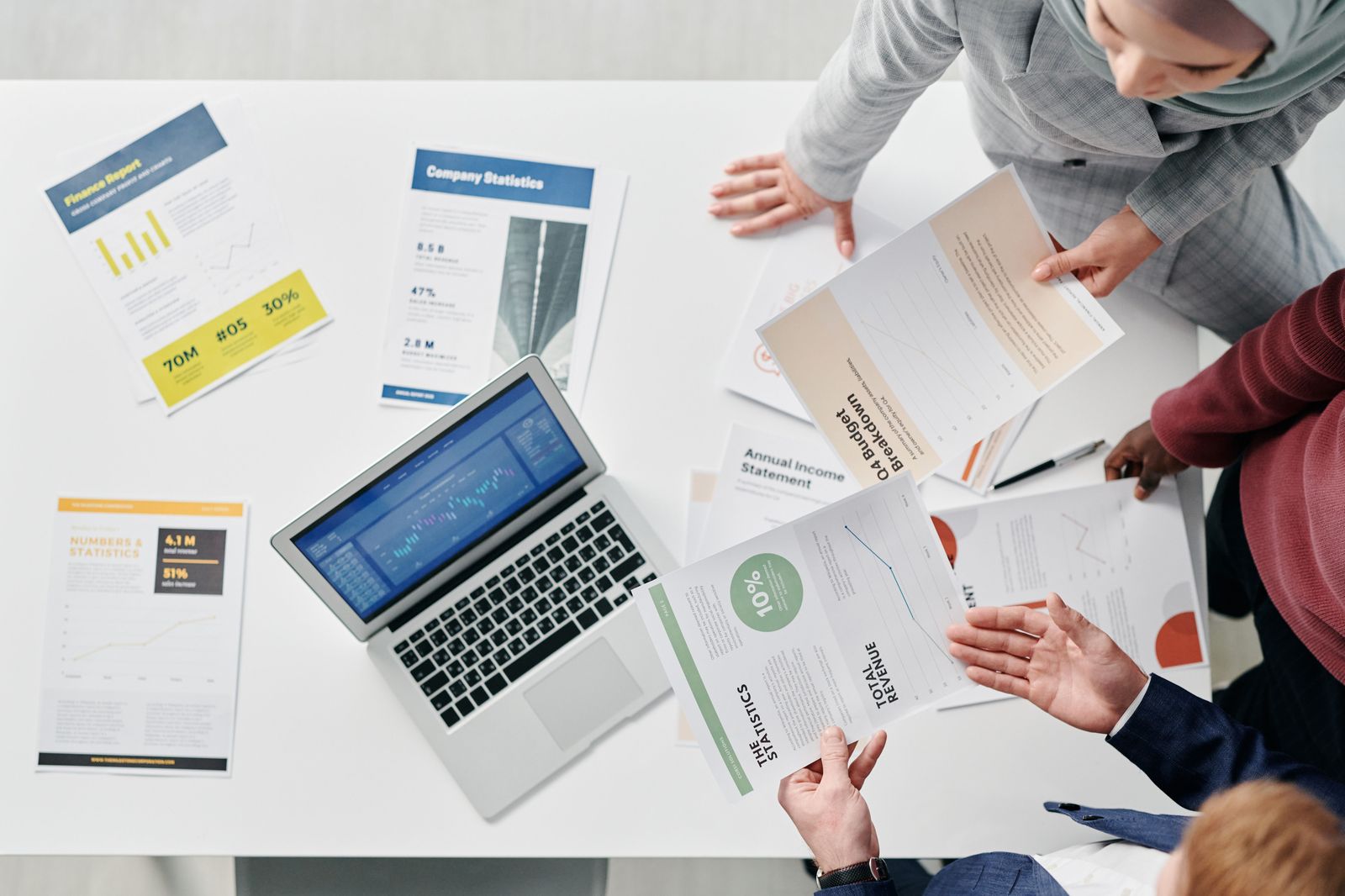 Engagement documents, analysis worksheets, and a laptop spread across a working table